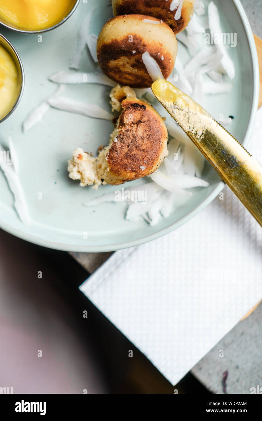 Vegan tofu cheese pancakes on blue plate, gray concrete table. Sun light. Food blog photography concept. Overhead Stock Photo