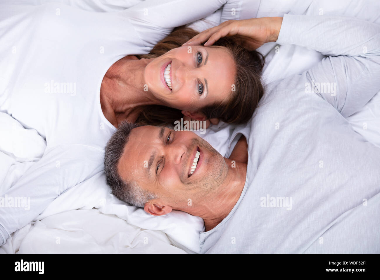 High Angle View Of Happy Mature Couple Lying On Bed Stock Photo - Alamy