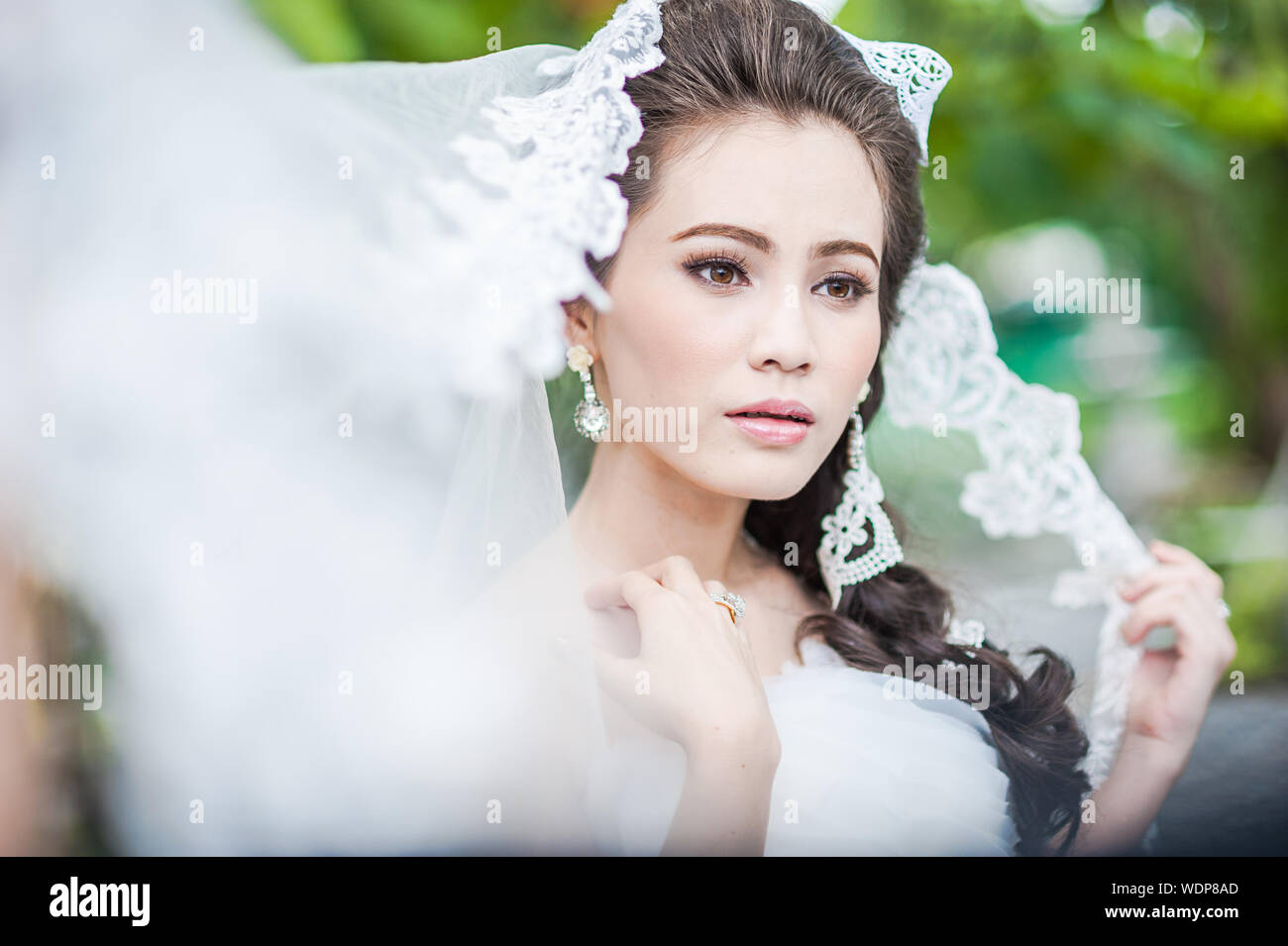 Bride Wearing Wedding Dress Standing At Park Stock Photo