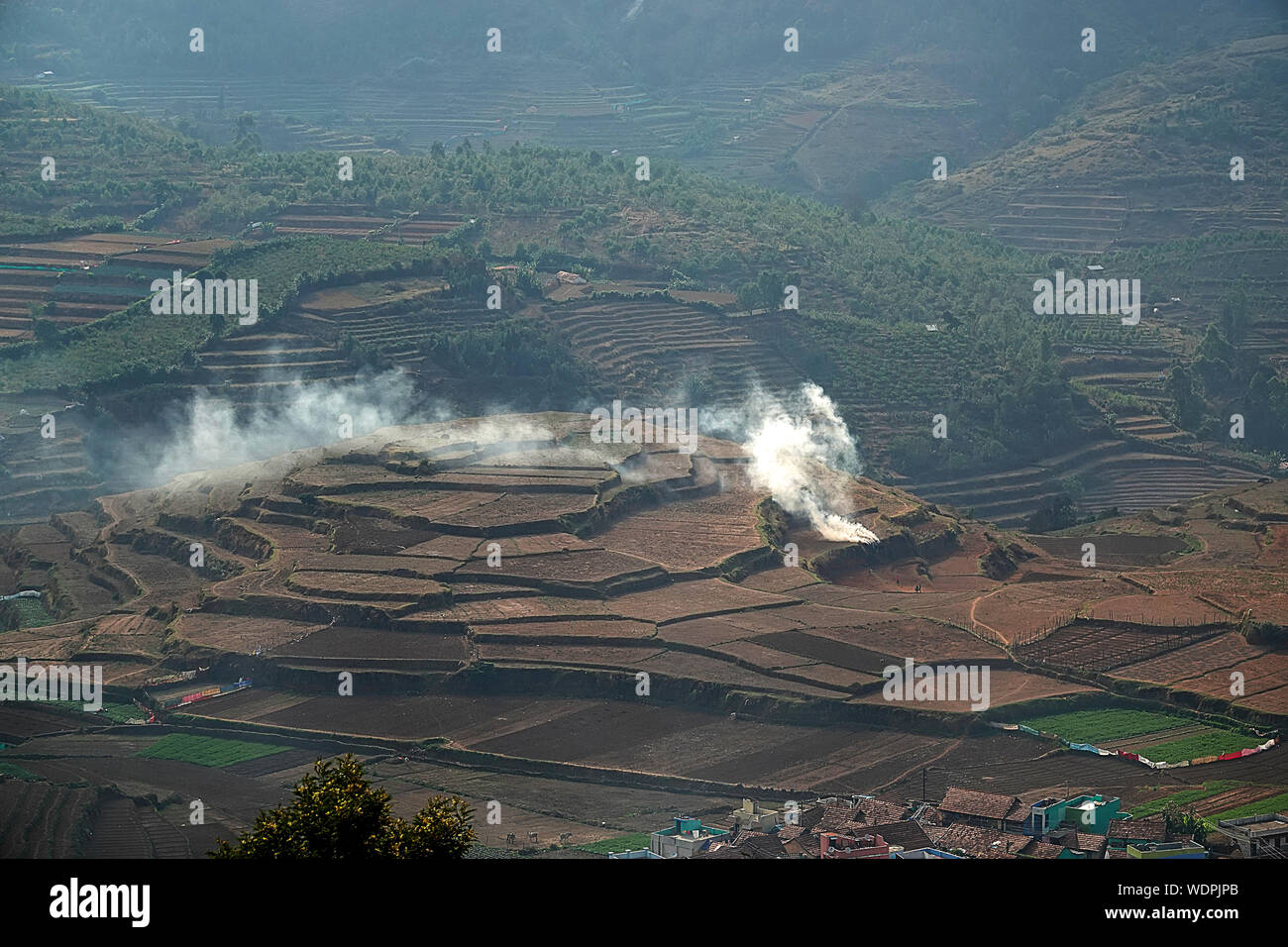 A local farmers burning the undergrowth of the land he owns, employing the traditional slash-and-burn cultivation method Stock Photo