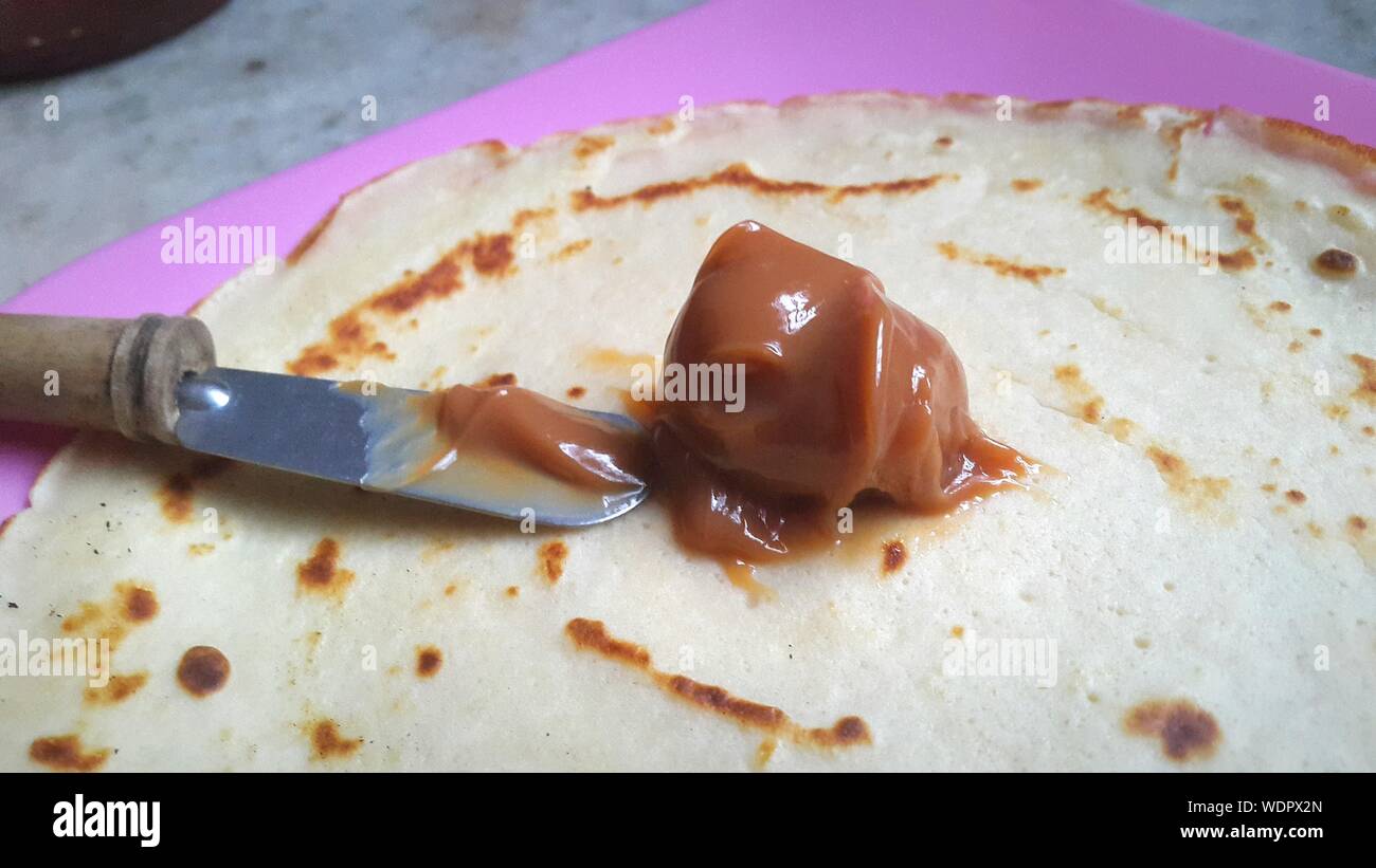 Close-up Of Dulce De Leche With Butter Knife On Flatbread Stock Photo