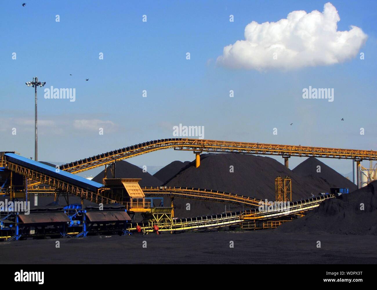 Low Angle View Of Metallic Structures At Coal Industry Against Sky Stock Photo