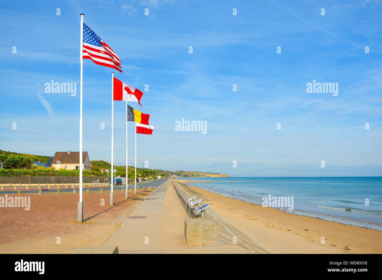 The landing at Normandy coast in France, at Omaha Beach memorial with a row of flags on a sunny day Stock Photo