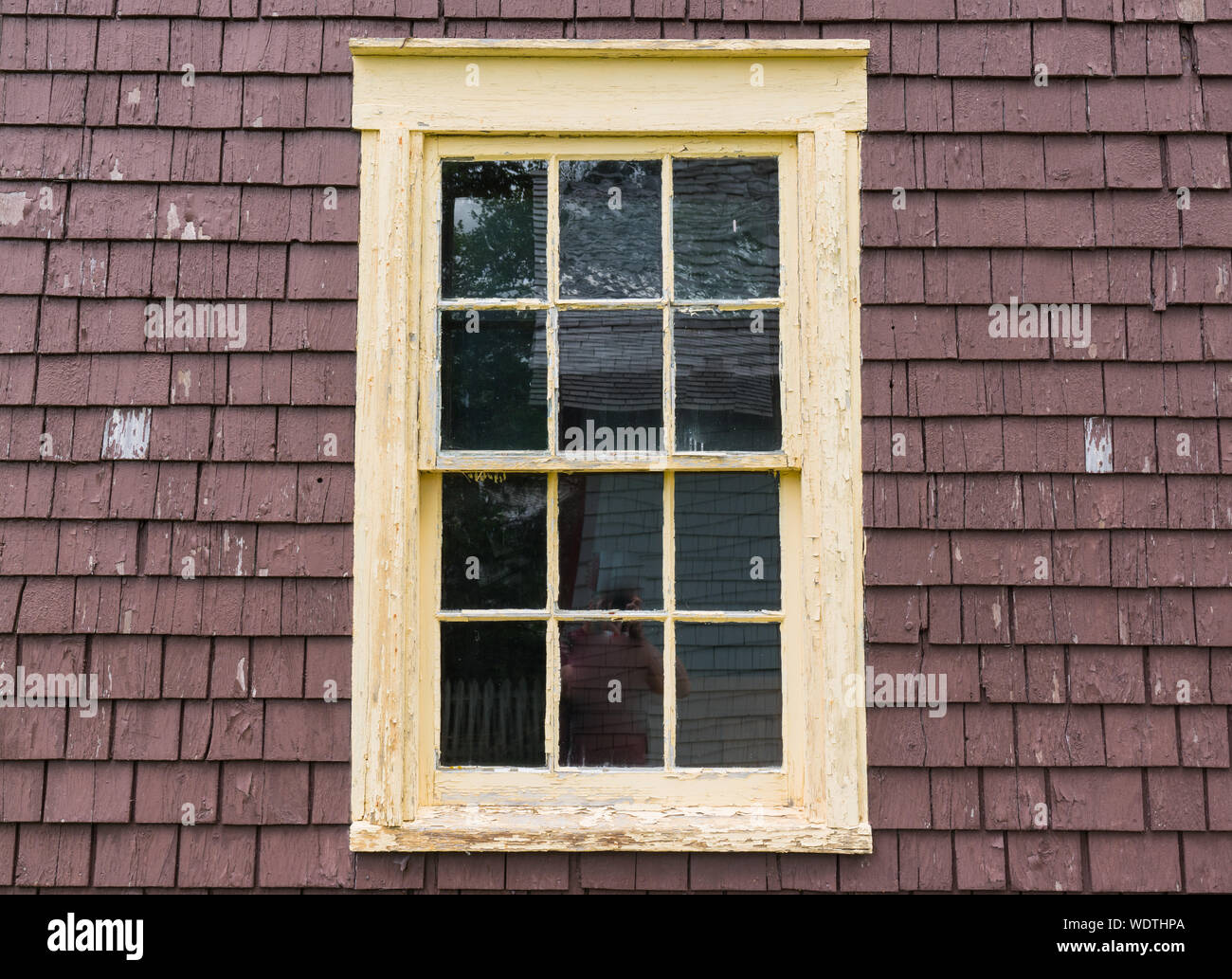 Old rustic yellow window frame with weathered peeling Stock Photo