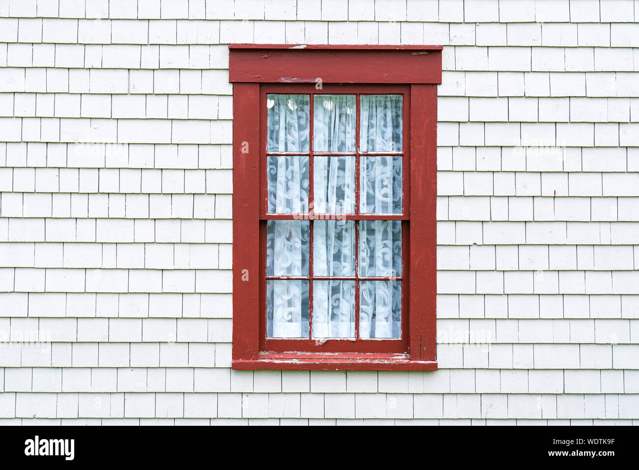 Old rustic red window frame on cedar shingles with weathered peeling Stock Photo
