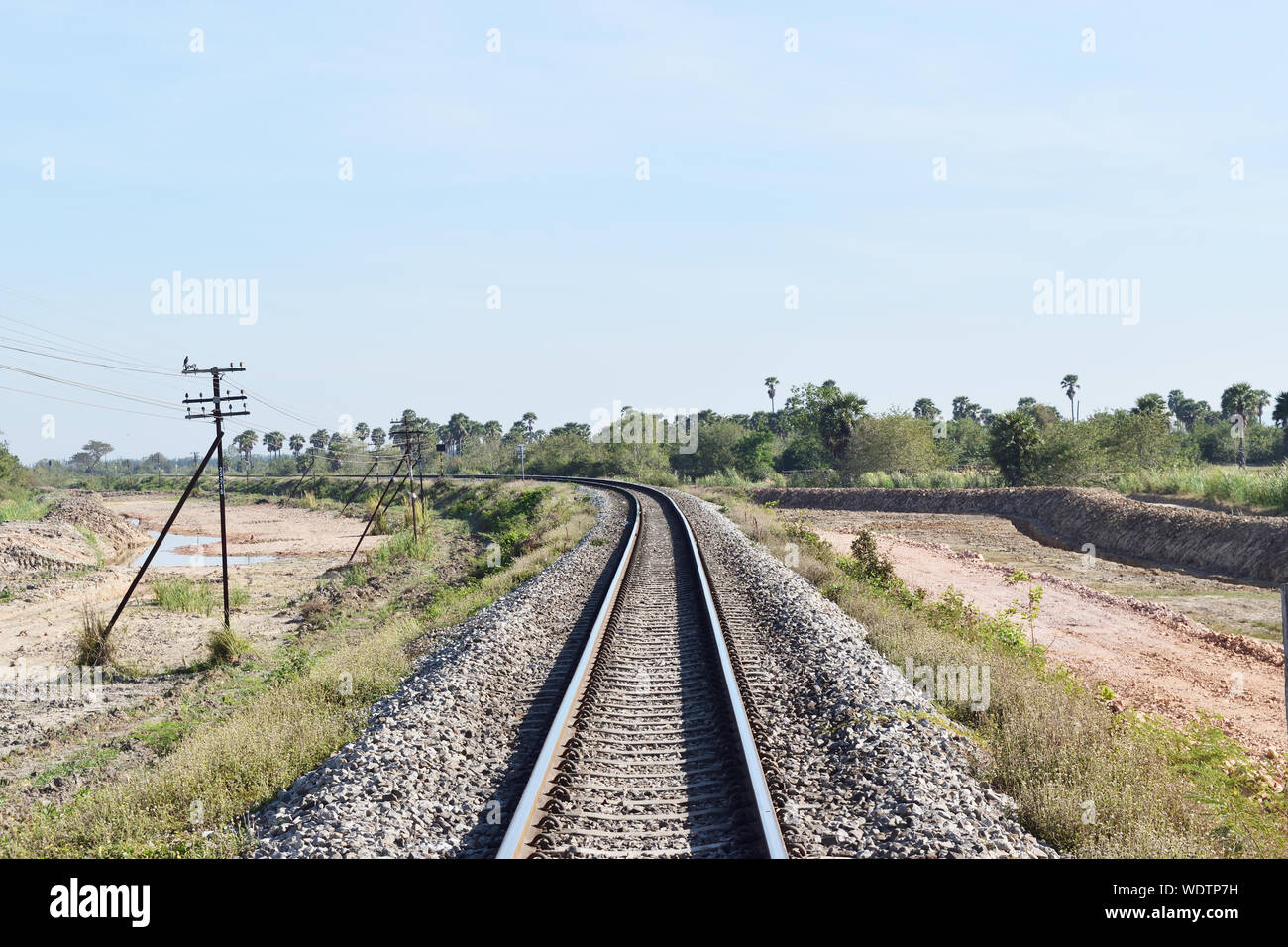 Railway with forest and telegraph pole along the way in Thailand, Old-style rail transport Stock Photo