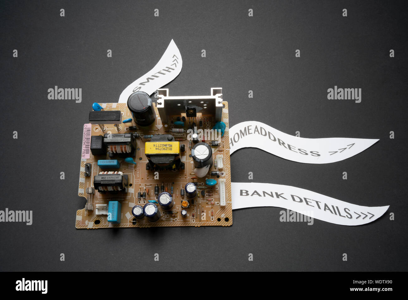 A circuit board with labels illustration data leaks, personal details and computer hacking in a big data warehousing world Stock Photo