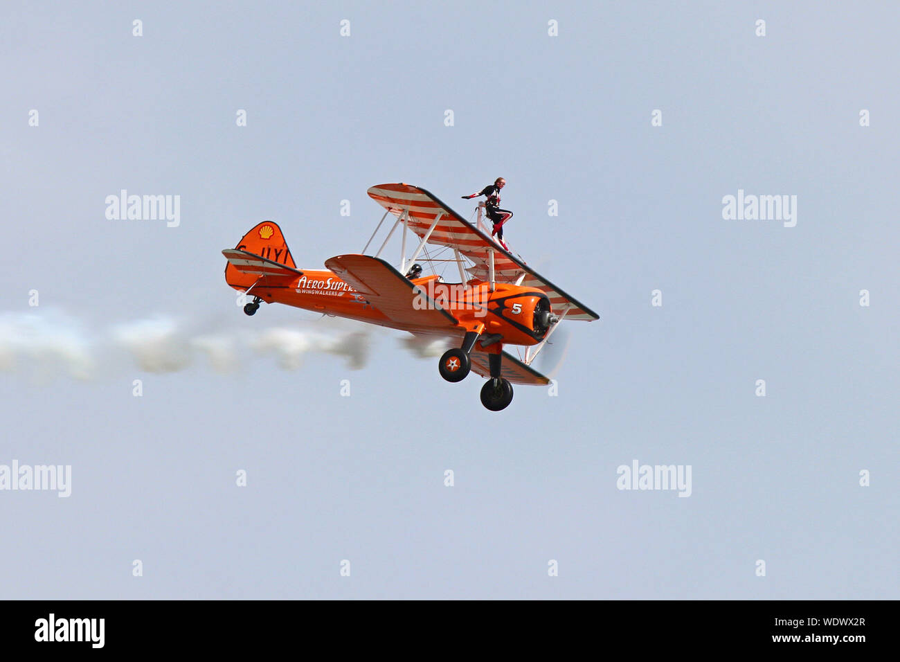 Part of the Aerosuperbatics Wingwalkers this 1940's biplane with the young lady strapped on top wows the crowd at Eastbourne's International Airshow. Stock Photo