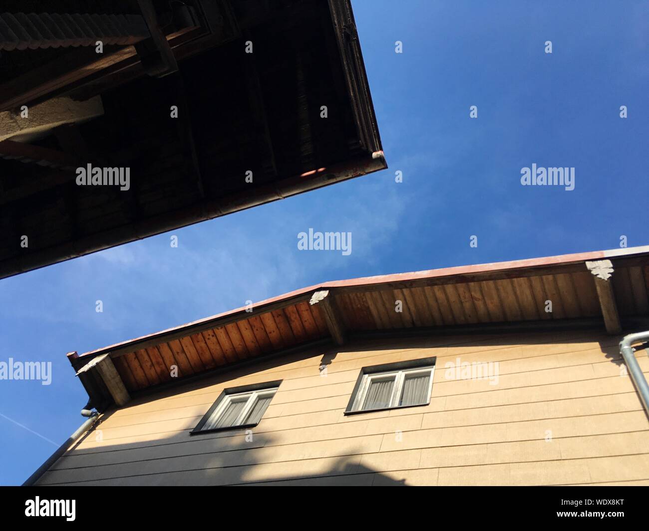 Low Angle View Of Wooden House Against Blue Sky Stock Photo