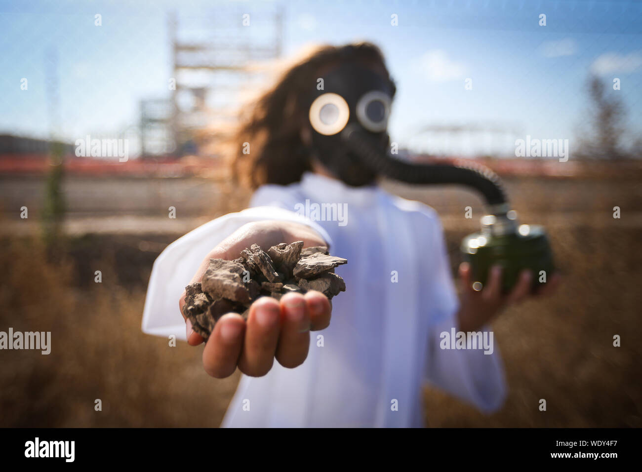 Girl Wearing Gas Mask While Holding Stones On Field Stock Photo Alamy