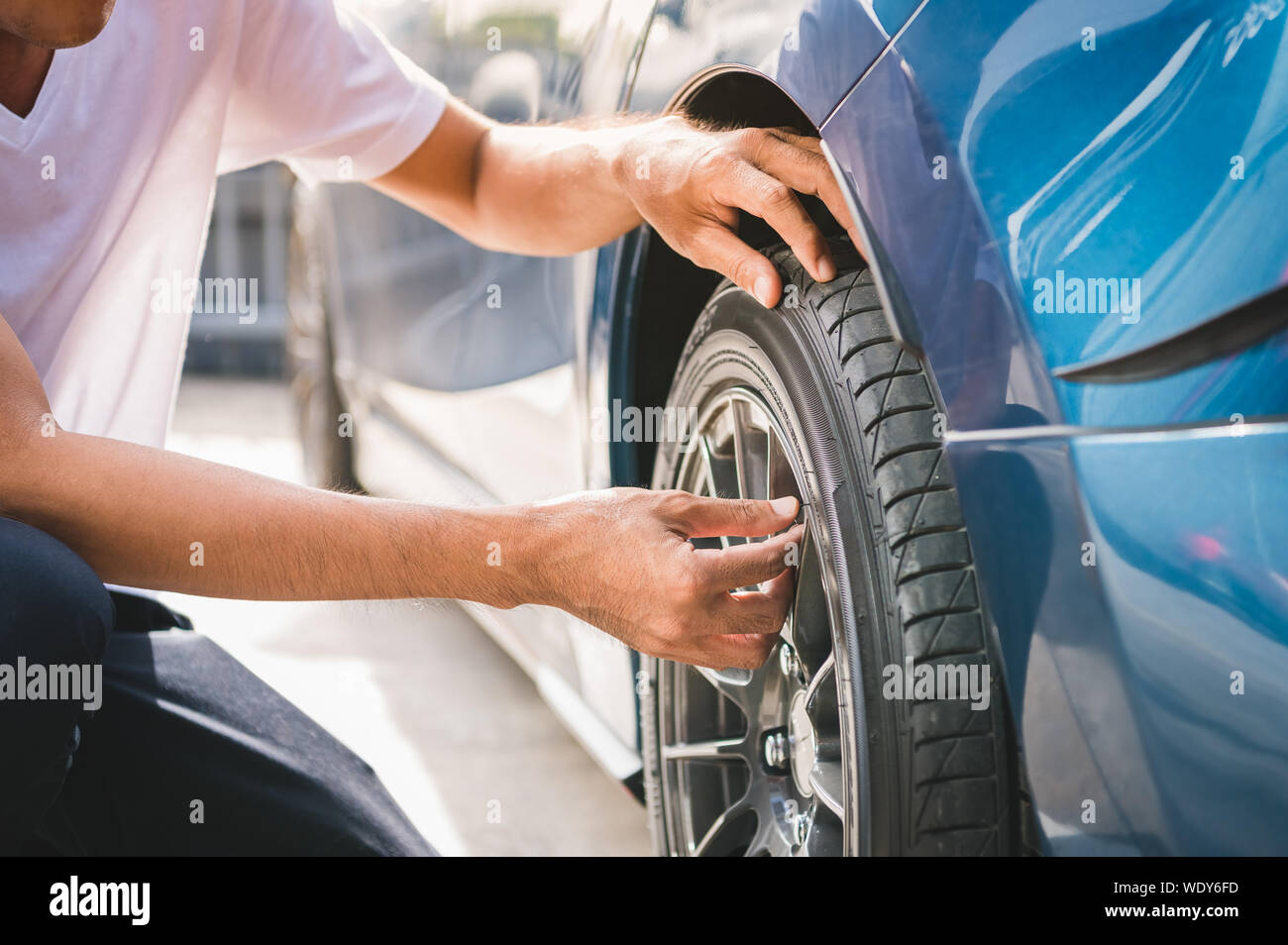 Closeup male automotive technician removing tire valve nitrogen cap for