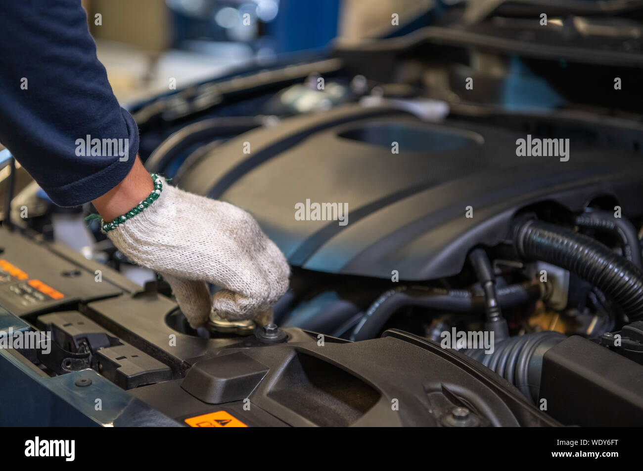 Closeup hand of auto mechanic examine car engine breakdown problem in