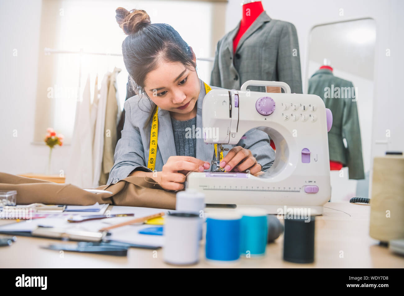 Attractive female fashion designer hand working in workshop with sewing  machine. Stylish fashionista woman creating new cloth design collection.  Tailo Stock Photo - Alamy