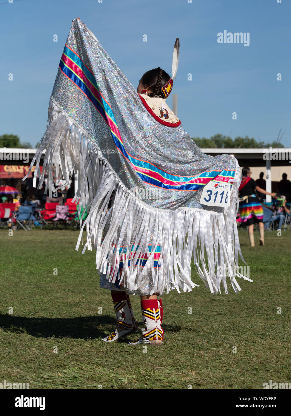 Native American woman wearing a shawl with white fringe over