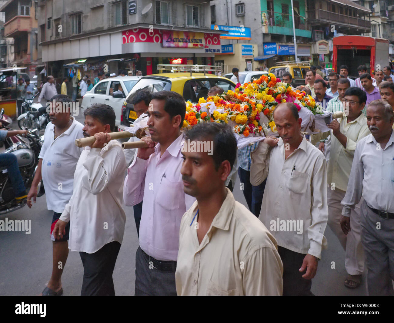 Relatives of a deceased Hindu carry the flowercovered body on a gurney