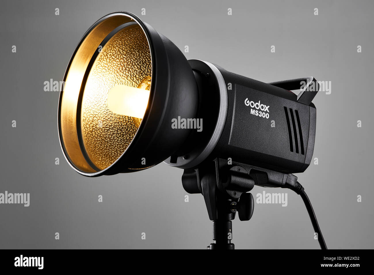 Brand new Godox MS300 photography studio flash head turned on in a photo studio environment. Stock Photo
