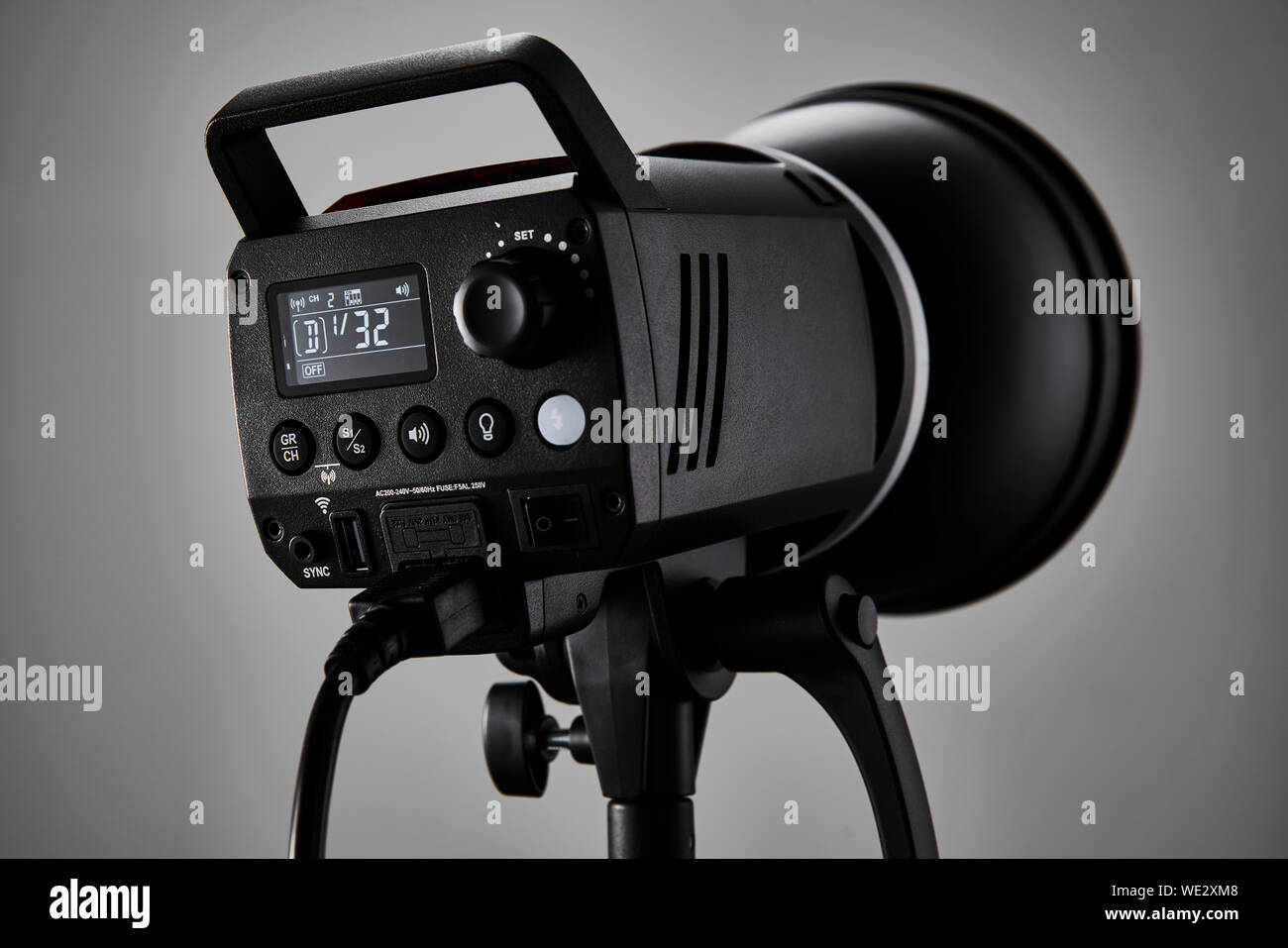 Brand new photography studio flash head turned on in a photo studio environment. Stock Photo