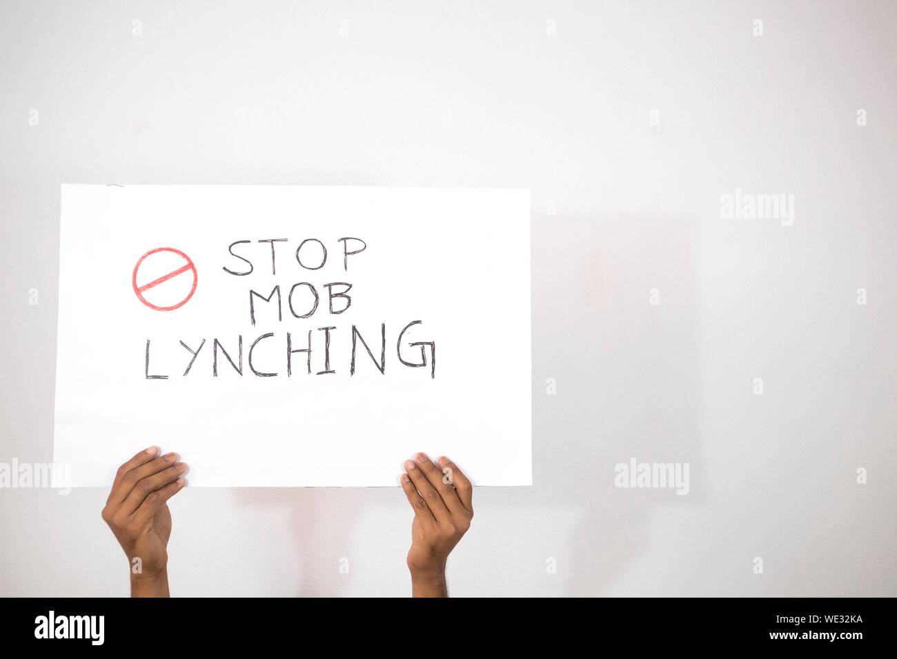 Hands with Placard showing of Stop Mob Lynching on isolated background. Stock Photo