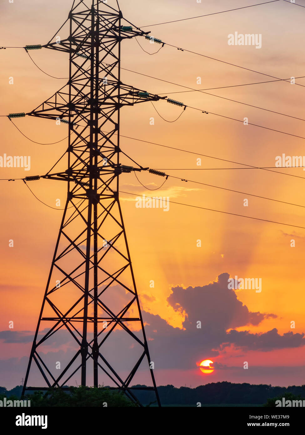 Power lines support tower at sunset. Environment and industry Stock Photo