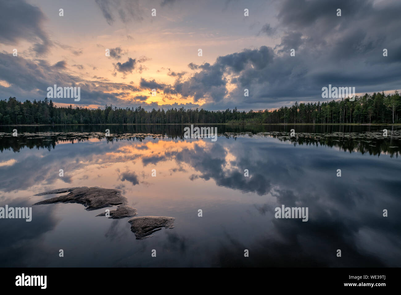 Scenic lake landscape with tranquility mood, sunset and beautiful reflections at summer evening in Finland Stock Photo