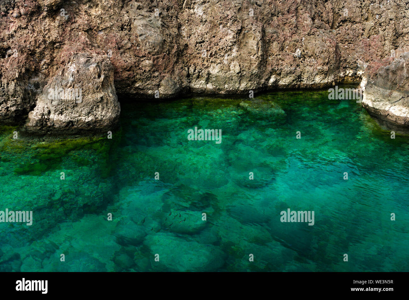 Shallow Water Against Rocks Stock Photo