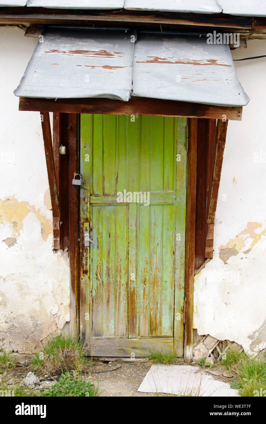 Weathered Green Wooden Door With A Small Metal Roof Stock Photo