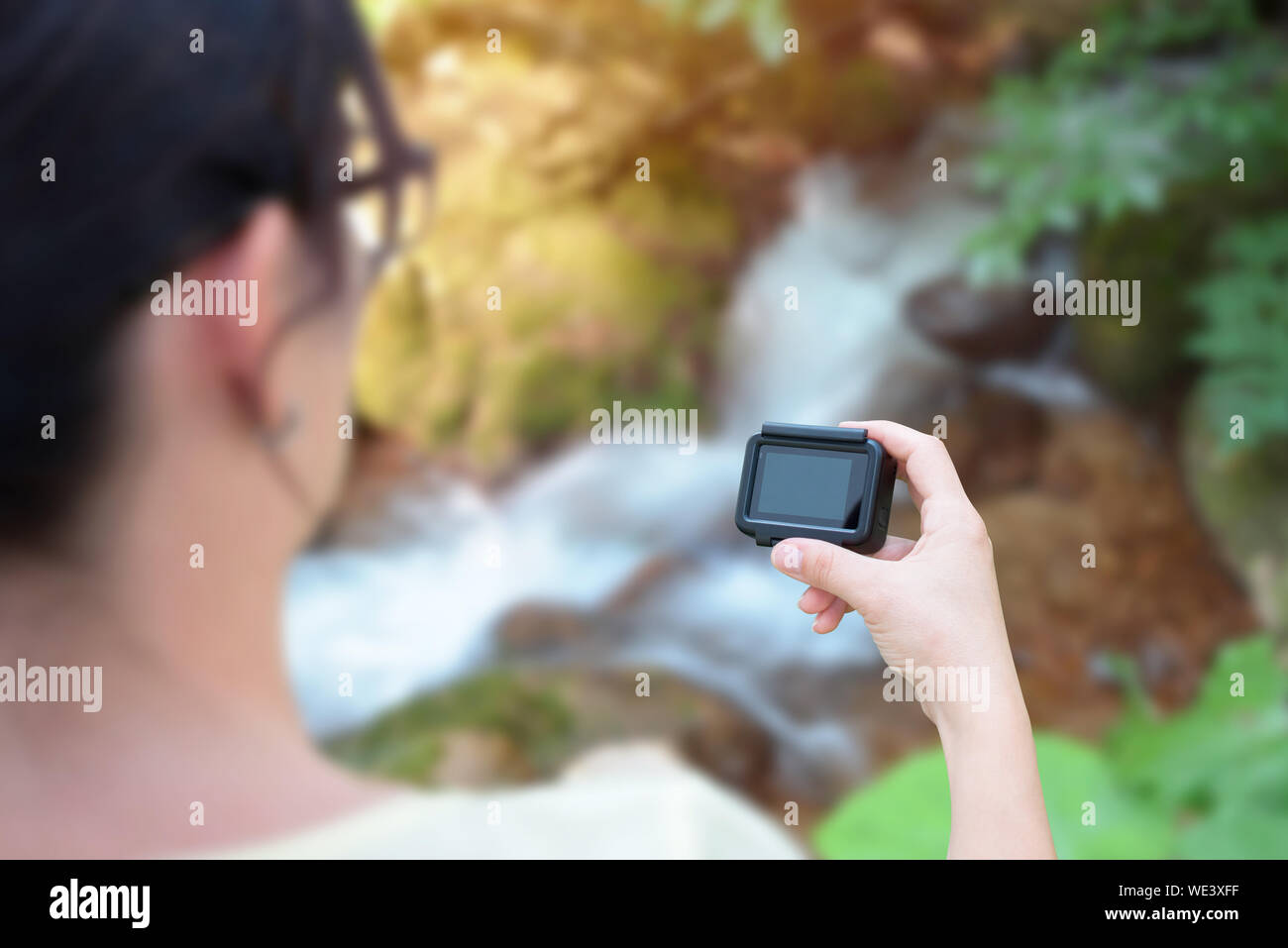 Woman filming nature with action camera concept. Blank screen for mockup. Stock Photo