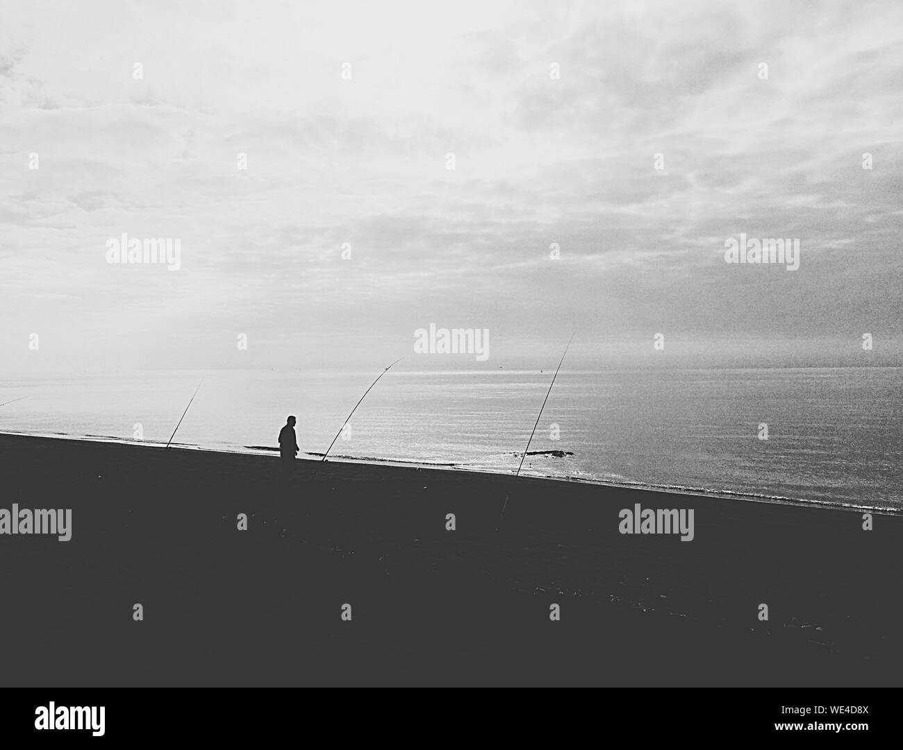 Silhouette Man Fishing At Beach Stock Photo - Alamy