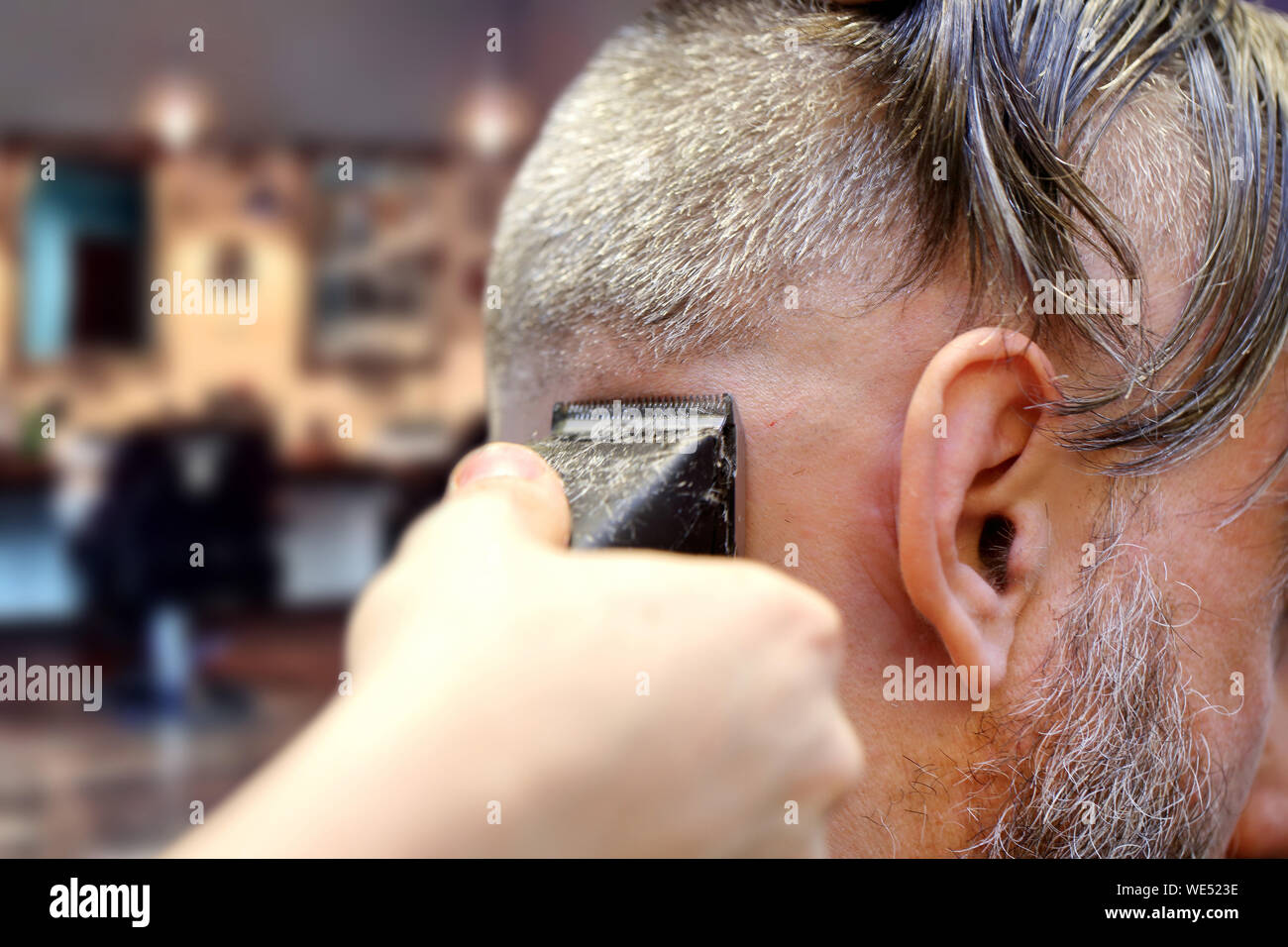 Barber making a haircut using trimmer cutting machine Stock Photo Alamy