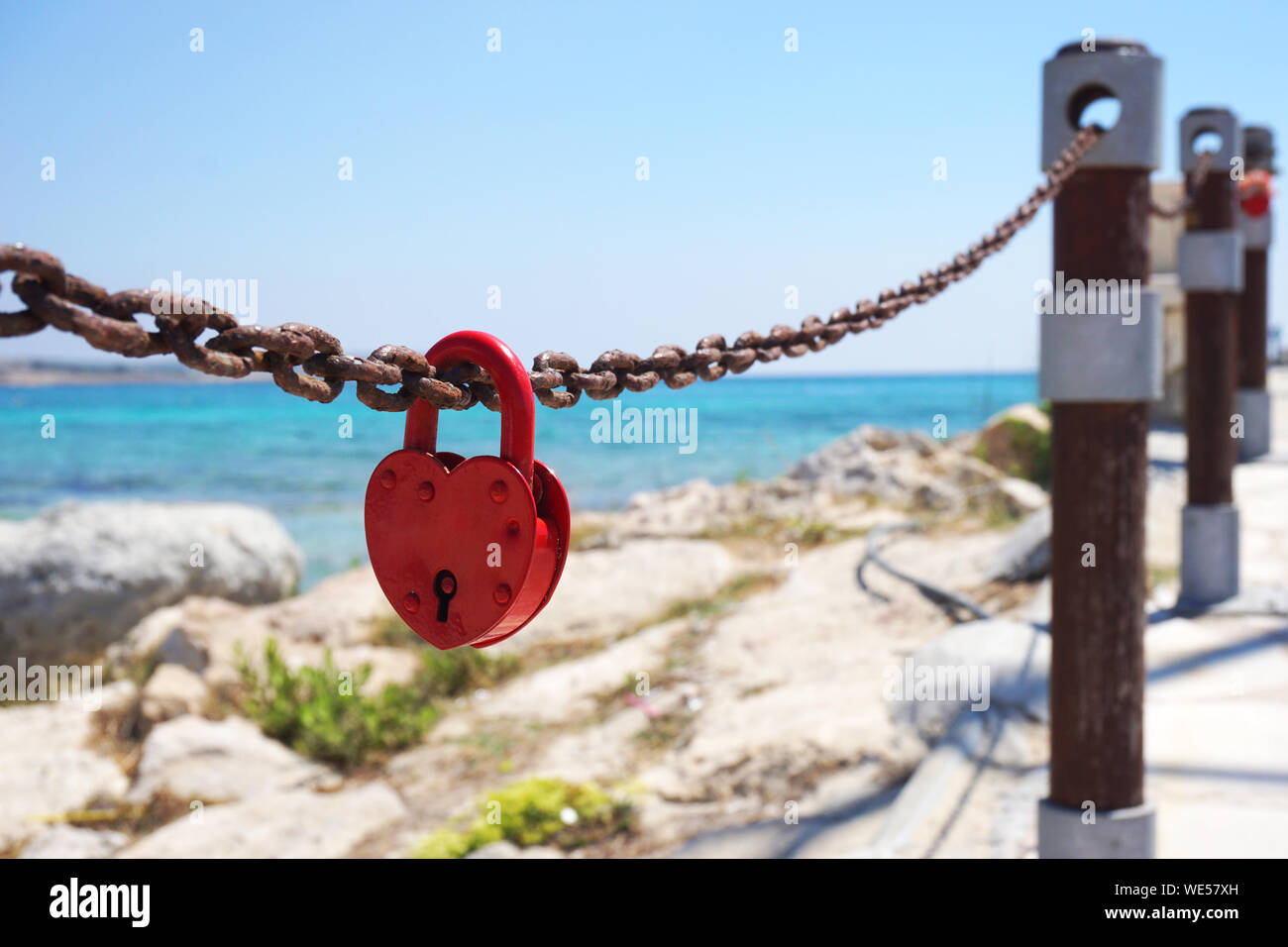 Red love padlock attached to chain. Rusty lock with heart shape carved ...