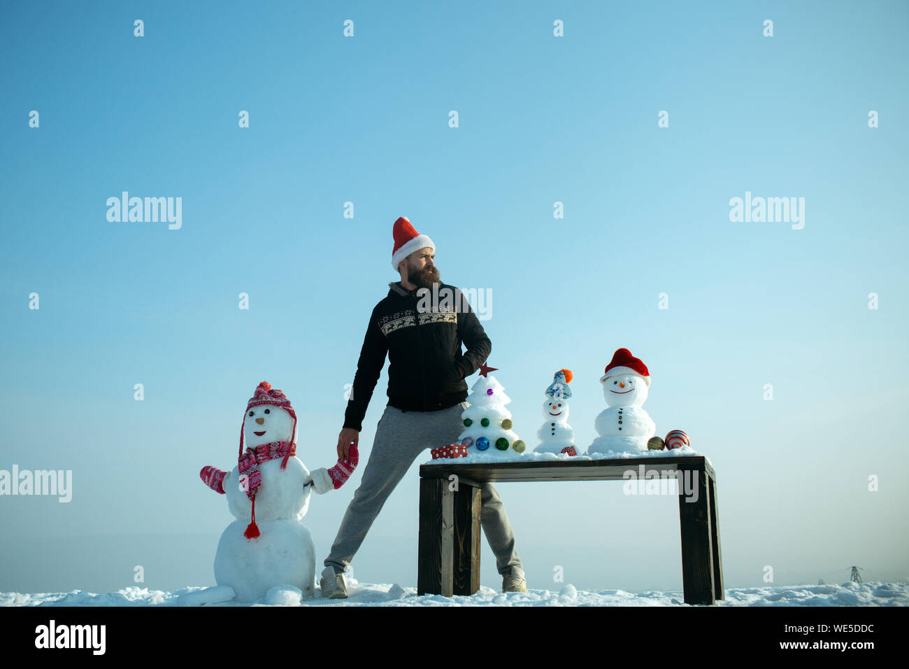 Man and snowman holding hands on blue sky Stock Photo - Alamy