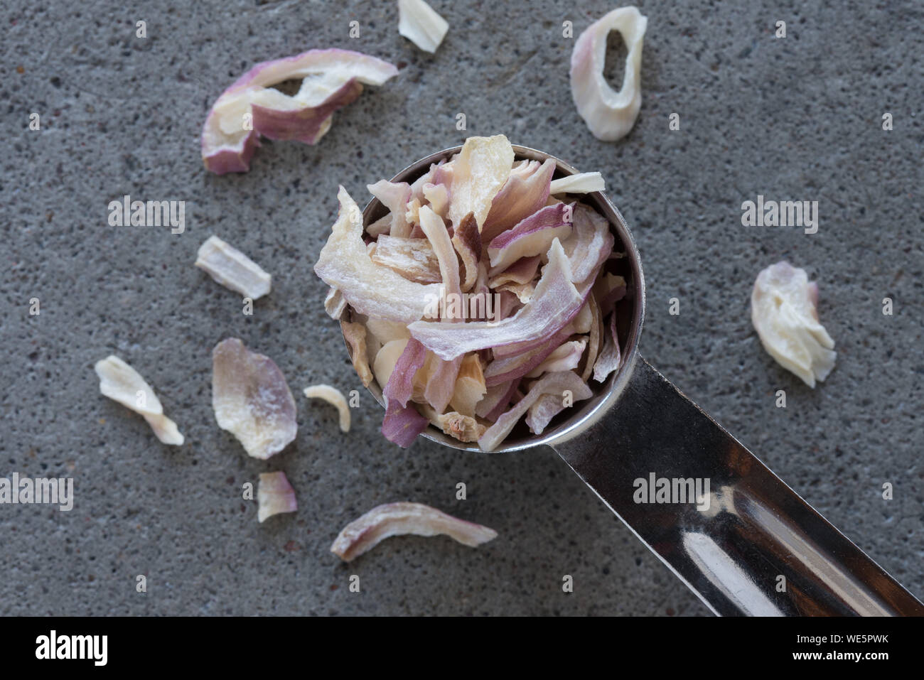 High Angle View Of Onion In Teaspoon Stock Photo