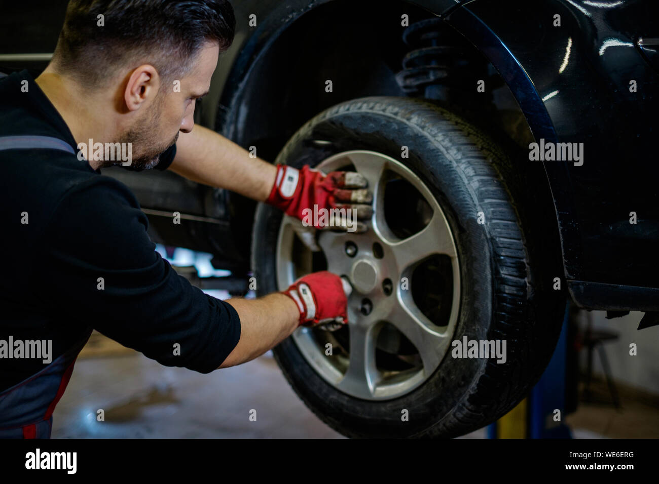 Car mechanic replacing wheel in a Stock Photo Alamy