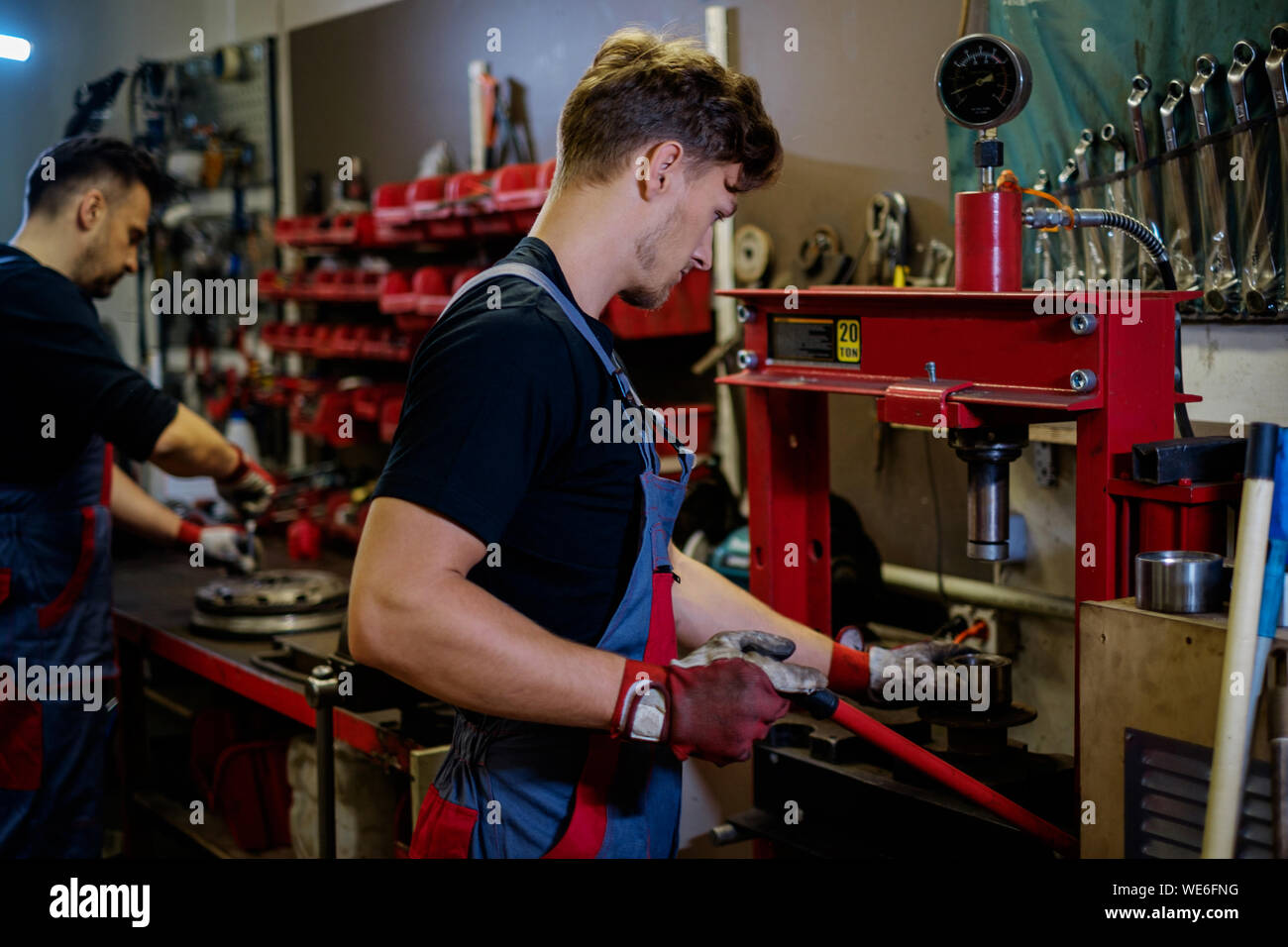 Car mechanic working on a hydraulic press in a Stock Photo Alamy