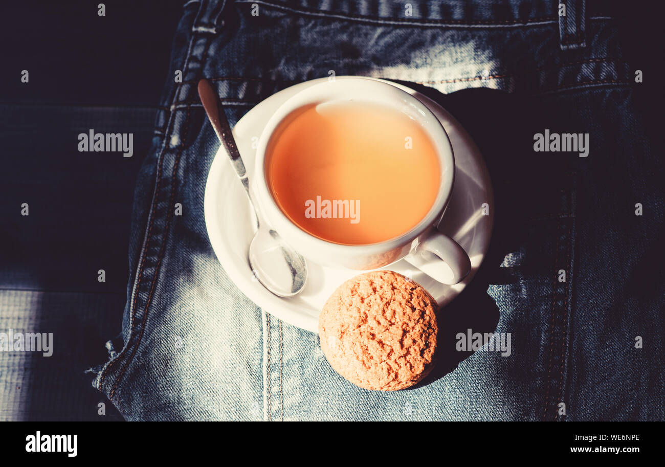 Quick snack concept. Relaxing chamomile tea. Cup mug hot tea and oat  cookie. Mug filled tea close up. Herbal green or black whole leaf. Process  tea brewing ceramic mug. Inspiration and peaceful