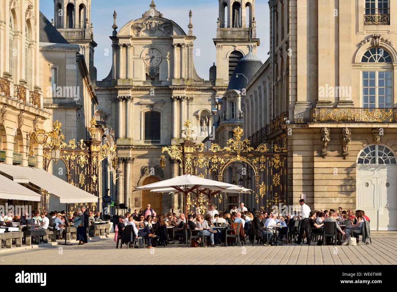 France, Meurthe and Moselle, Nancy, place Stanislas (former Place Royale) built by Stanislas Leszczynski, king of Poland and last duke of Lorraine in the eighteenth century, classified World Heritage of UNESCO, terrace of the hotel cafe Le Grand Hôtel with the cathedral Notre-Dame-de-l'Annonciation Stock Photo