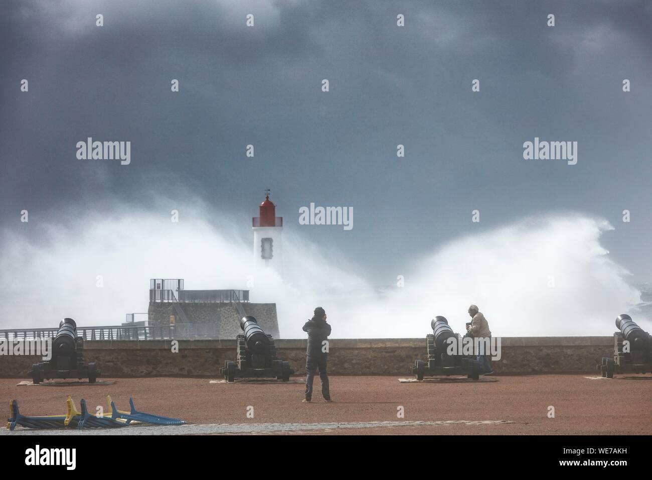 France, Vendee, Les Sables d'Olonne, people watching the harbour channel lighthouse in Miguel storm Stock Photo