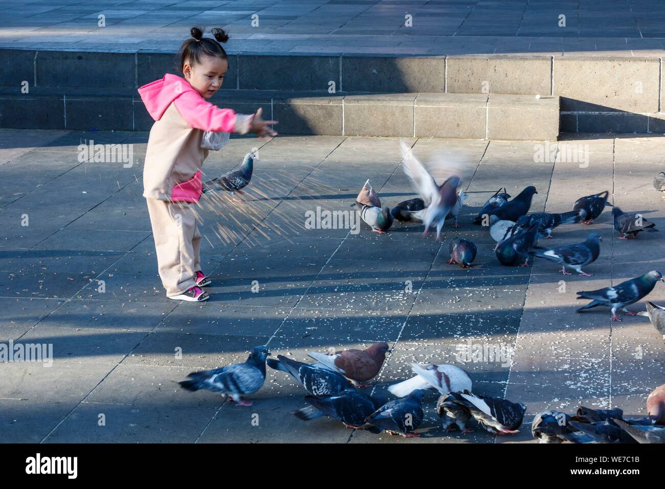 Mexico, Michoacan state, Patzcuaro, a little girl feeding pigeons Stock Photo