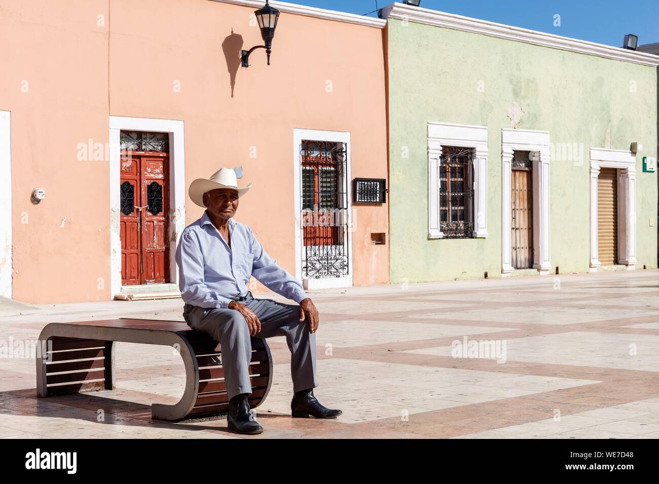 Mexico, Campeche state, Campeche, fortified city listed as World Heritage by UNESCO, a man with a hat sitting before colonial houses Stock Photo
