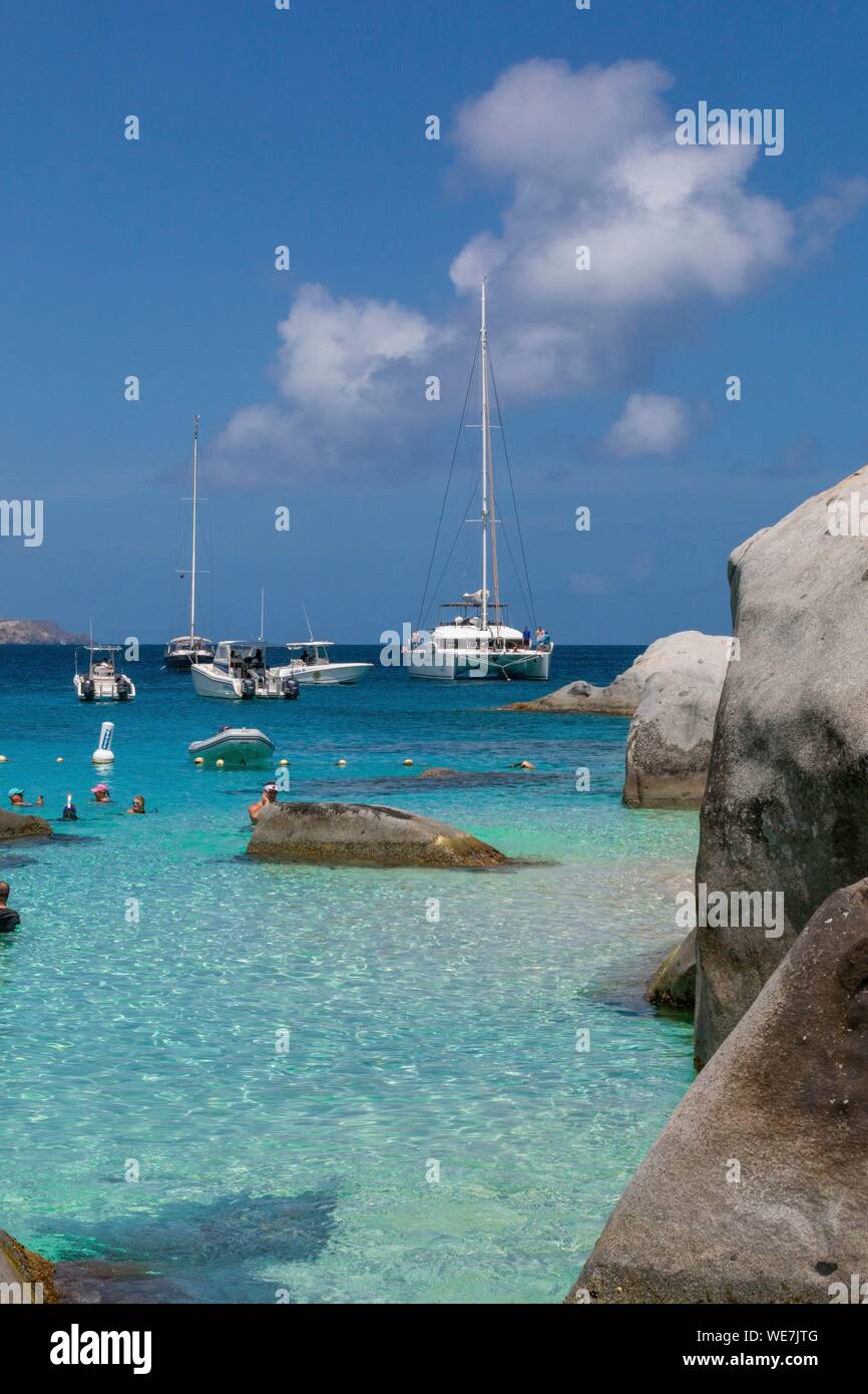 West Indies, British Virgin Islands, Virgin Gorda Island, The Baths, view of the bathing beach, sailboats and motor boats at anchor, in the foreground the typical rocks that surround the paradisiacal swimming area Stock Photo