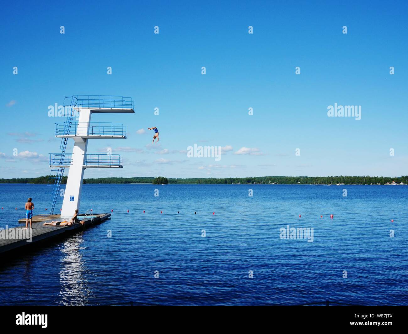 Man diving off platform into lake hires stock photography and images