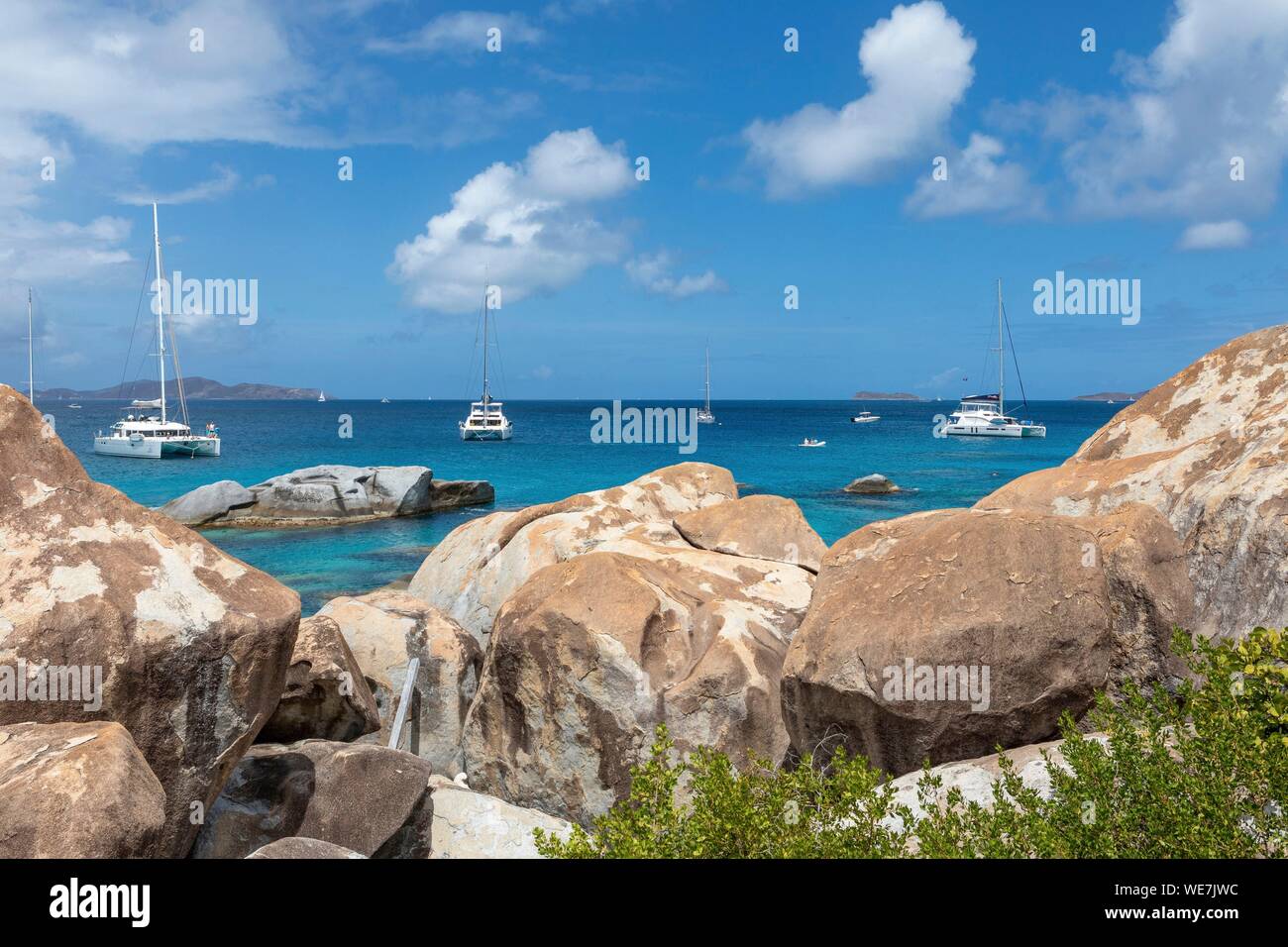 West Indies, British Virgin Islands, Virgin Gorda Island, The Baths, view of the bathing beach, sailboats and motor boat at anchor, in the foreground the typical rocks that surround the paradisiacal swimming area Stock Photo