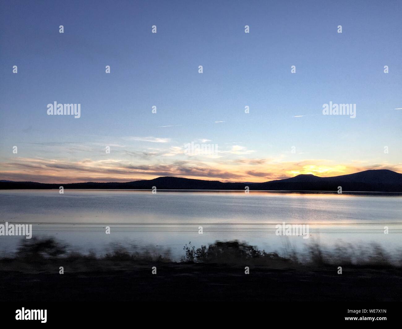 Scenic View Of Lake Against Sky During Sunset Stock Photo