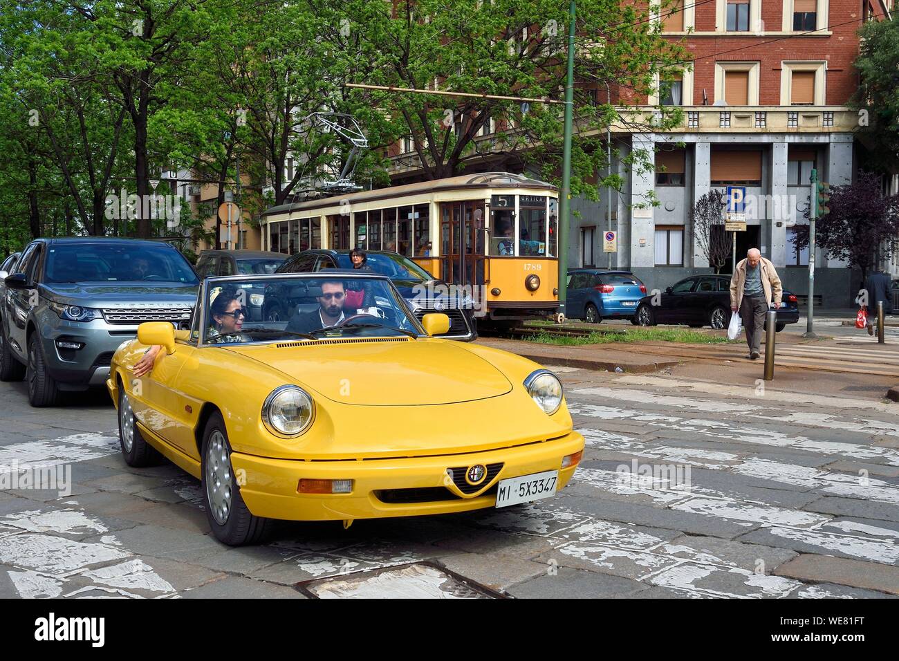 Italy, Lombardy, Milan, Alfa Romeo Duetto Spider yellow cabriolet in the streets of the city Stock Photo