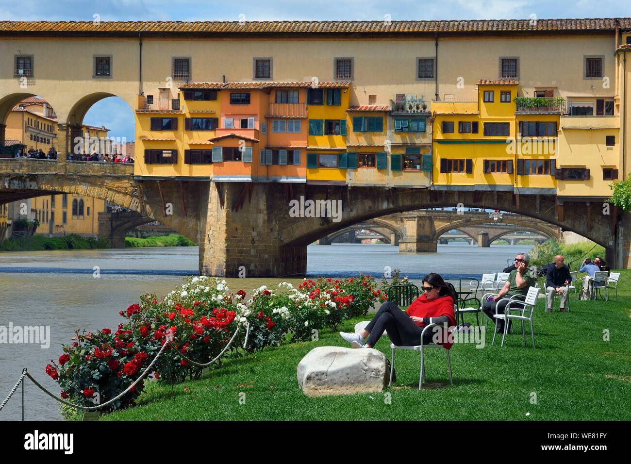 Italy, Tuscany, Florence, listed as World Heritage by UNESCO, the Ponte  Vecchio seen from the Societa Canottieri Firenze (Florence Rowing Club),  club members having a rest on the edge of the Arno
