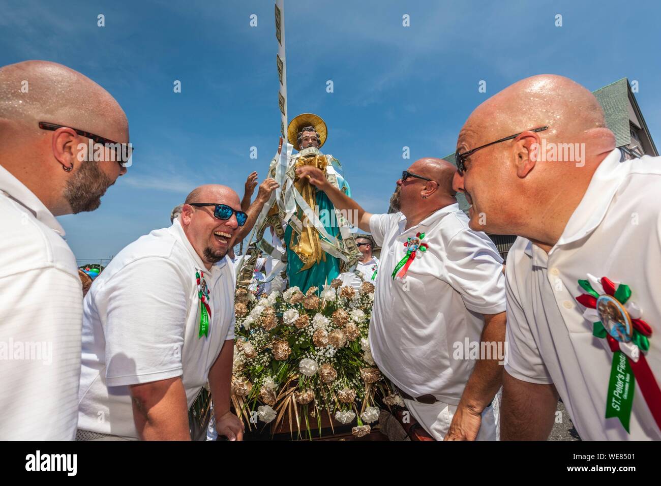 United States, New England, Massachusetts, Cape Ann, Gloucester, Saint Peters Fiesta, Traditional Italian Fishing Community Festival, men attaching ropes of money donations to the statue of St. Peter Stock Photo