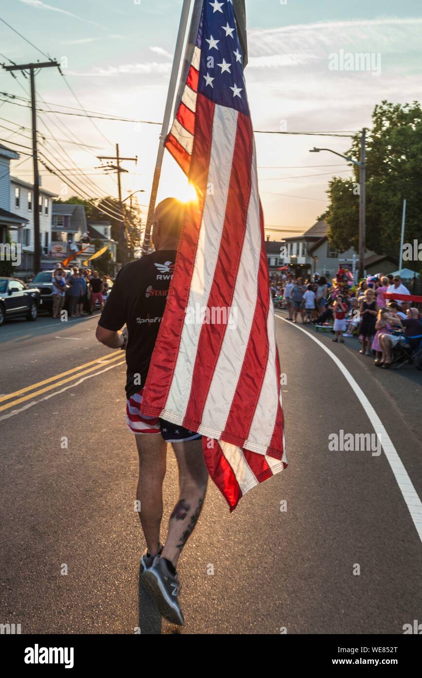 United States, New England, Massachusetts, Cape Ann, Gloucester, Gloucester Horribles Traditional Parade, July 3, man marching with US flag Stock Photo