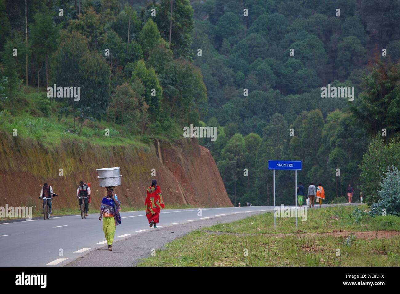 Rwanda, center of the country, woman walking on on the side of the road with basins on her head Stock Photo