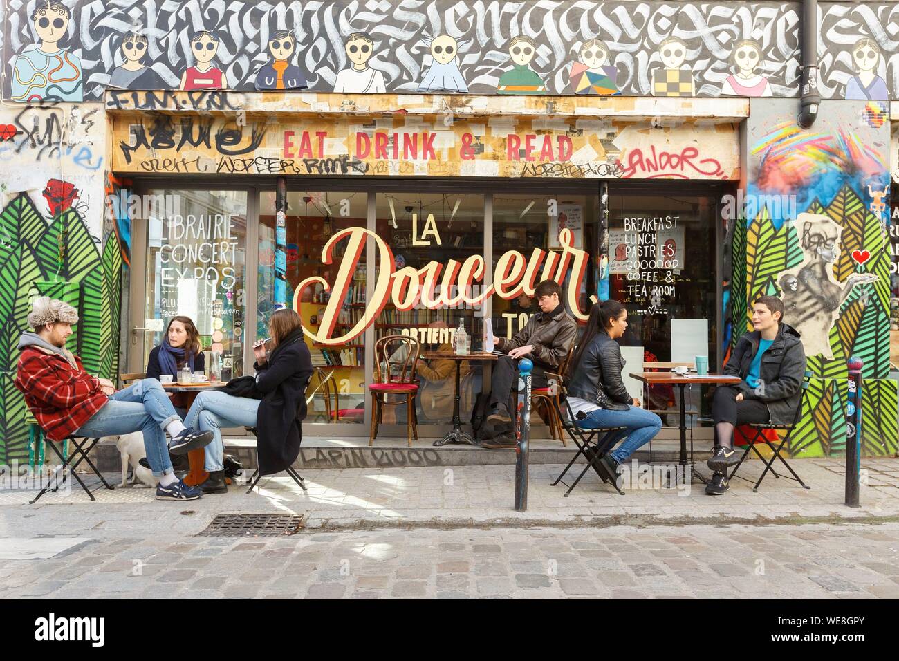 France, Paris, street art, graffitis and murals in Rue Denoyez, the terrace of the Barbouquin, cafe and bookstore Stock Photo