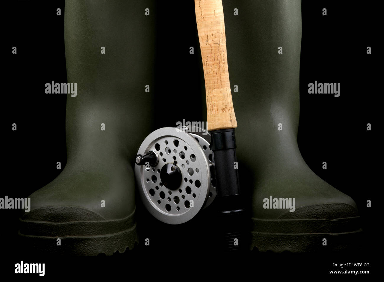 Traditional fly fishing rod and reel with green rubber wading boots